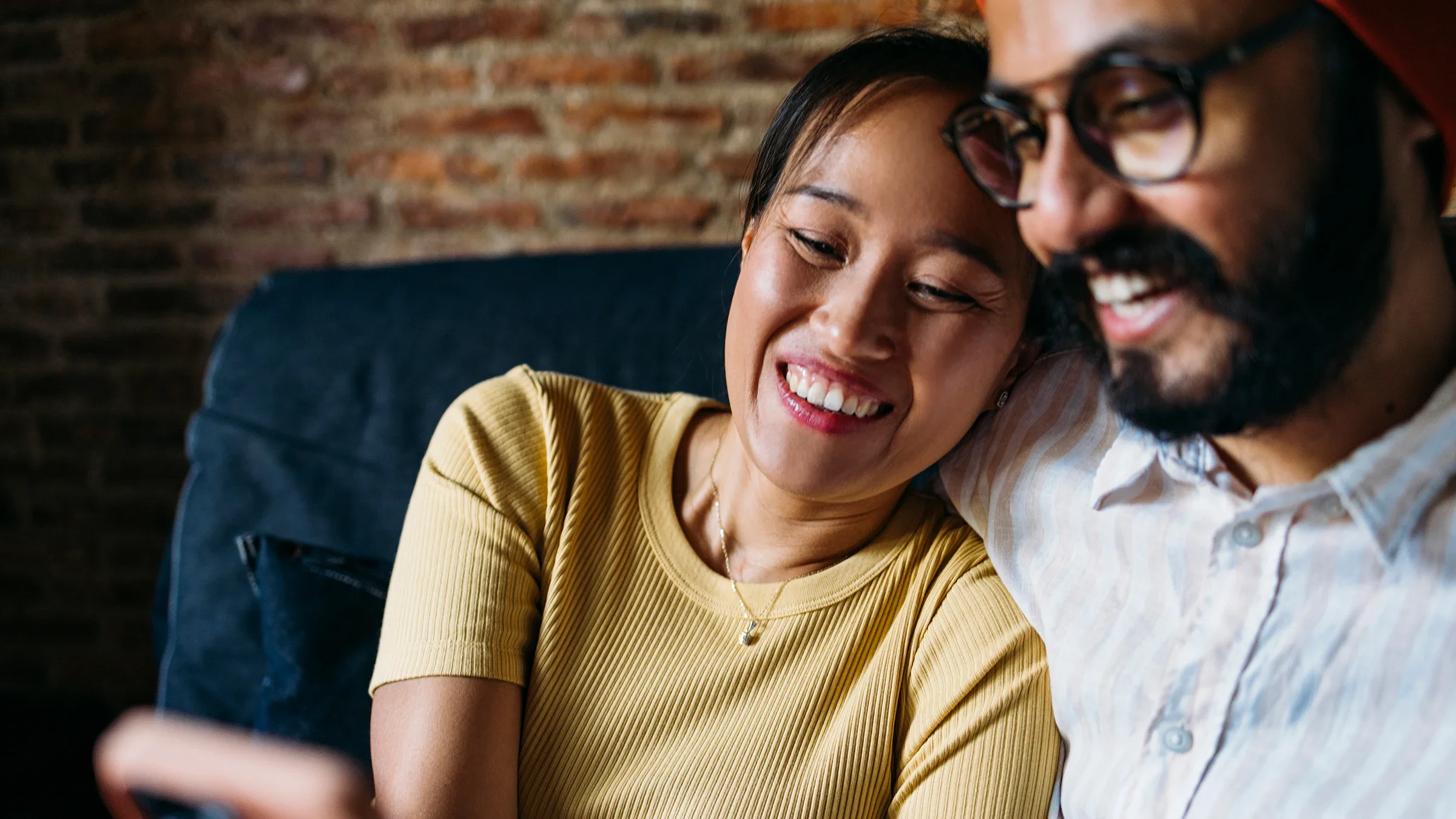 A couple is cuddled up and looking at a smartphone together at home.
FreshSplash/E+ via Getty Images 
