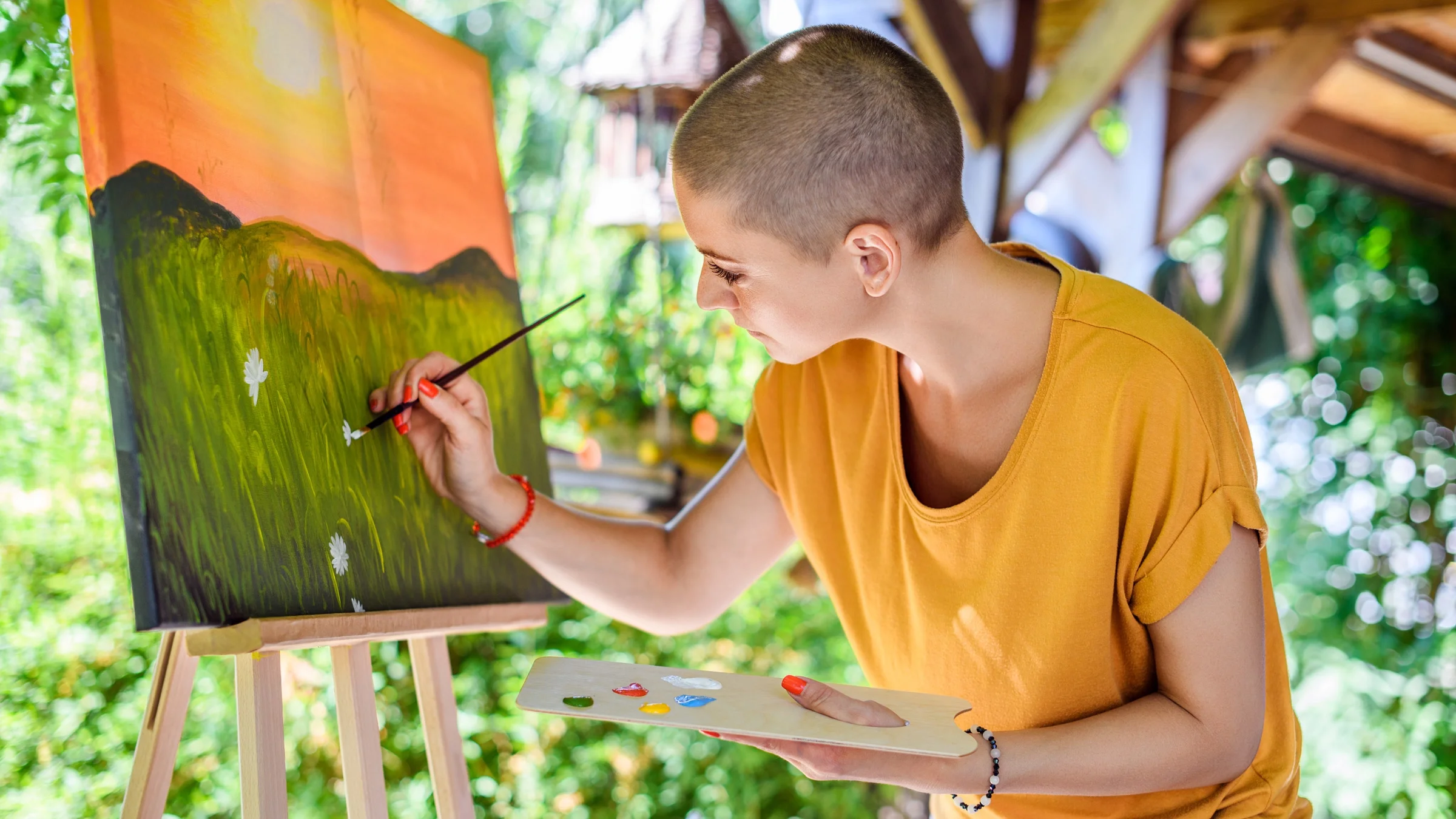 A cancer patient painting a landscape.