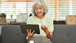 An older woman holding a computer tablet and a pill bottle.
PrathanChorruangsak/iStock via Getty Images Plus 