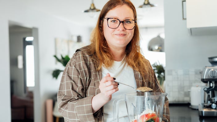 Woman making a smoothie in the kitchen.