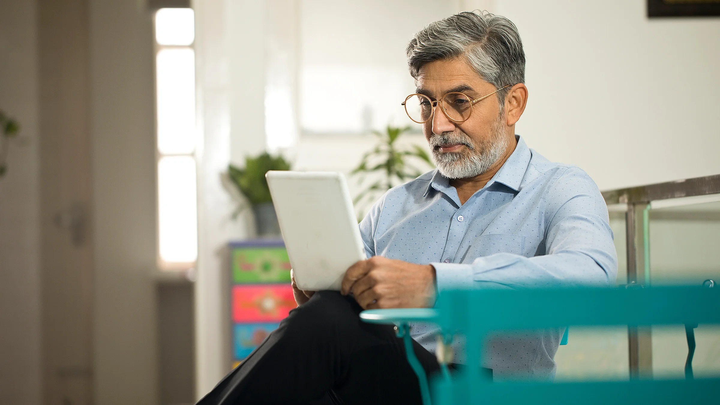 Older man using a tablet to play brain training games at home.