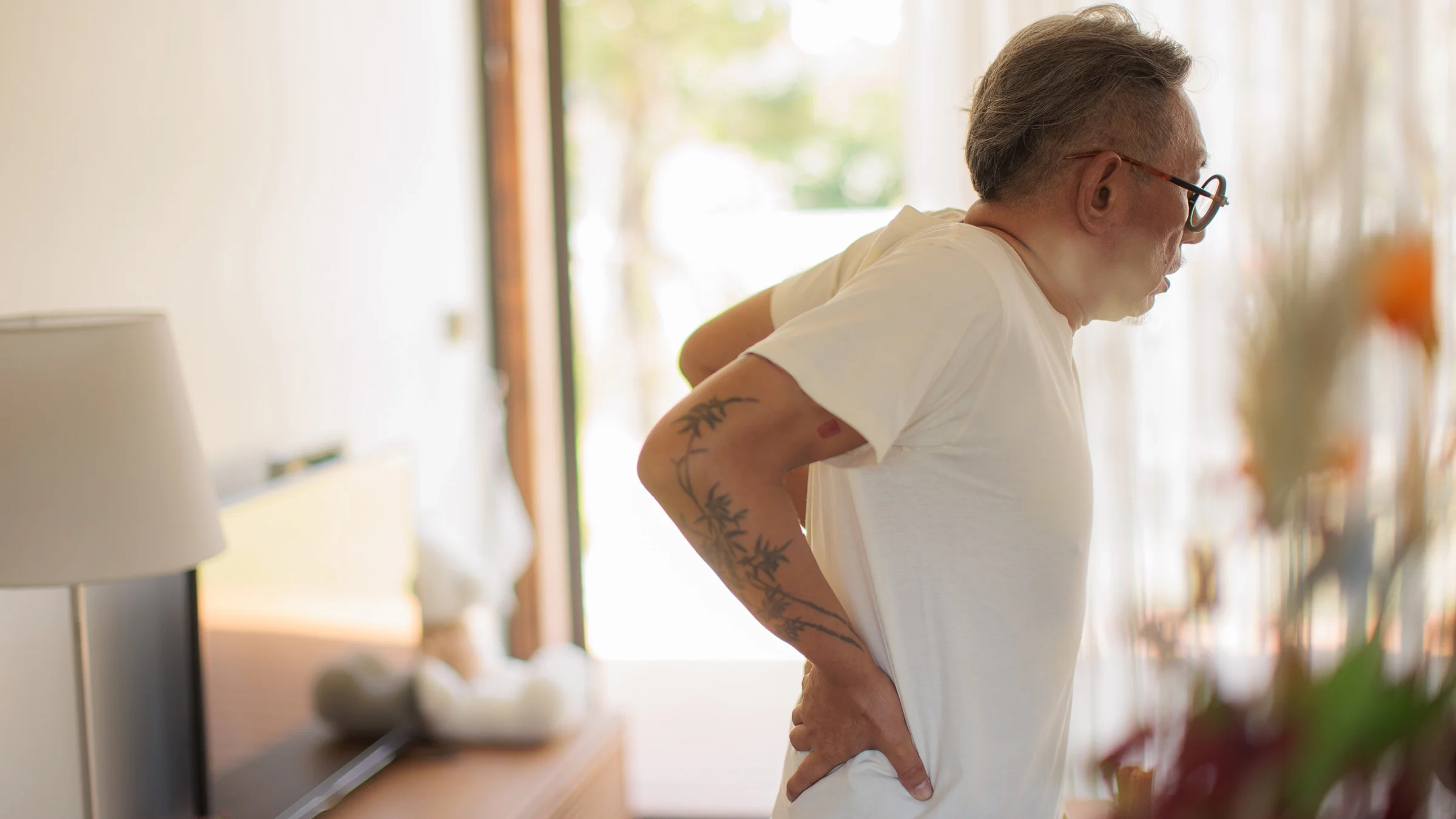 Man doing standing back extension stretch.