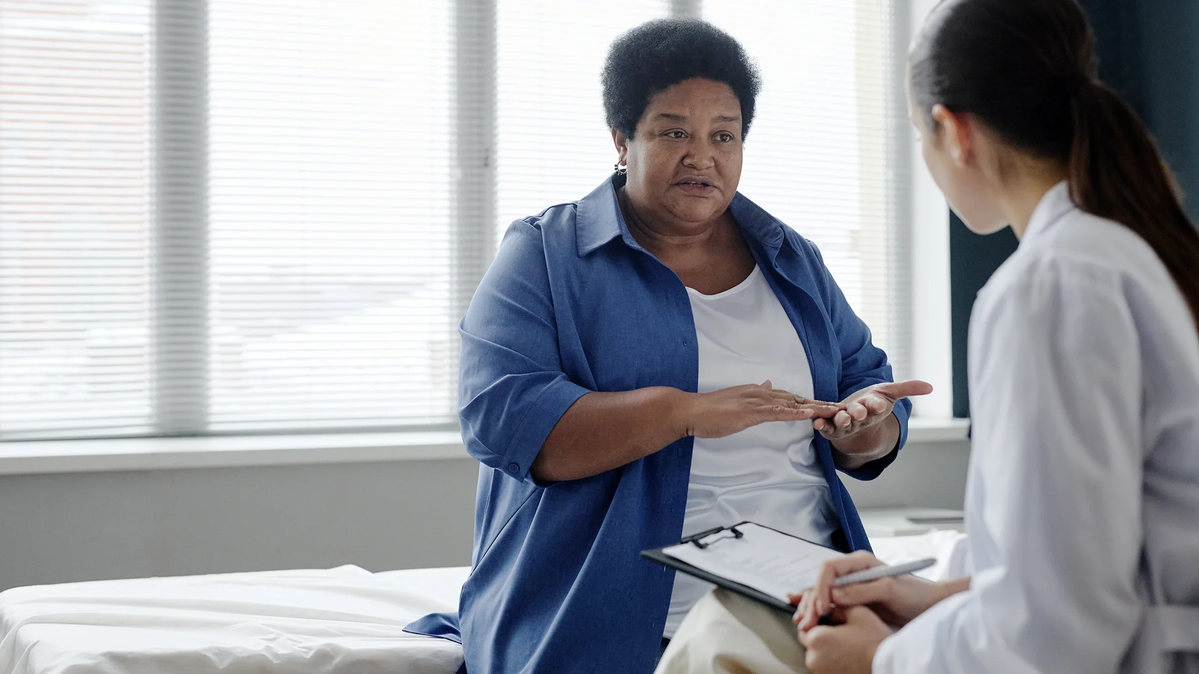 A woman speaks with a healthcare professional at a medical appointment.