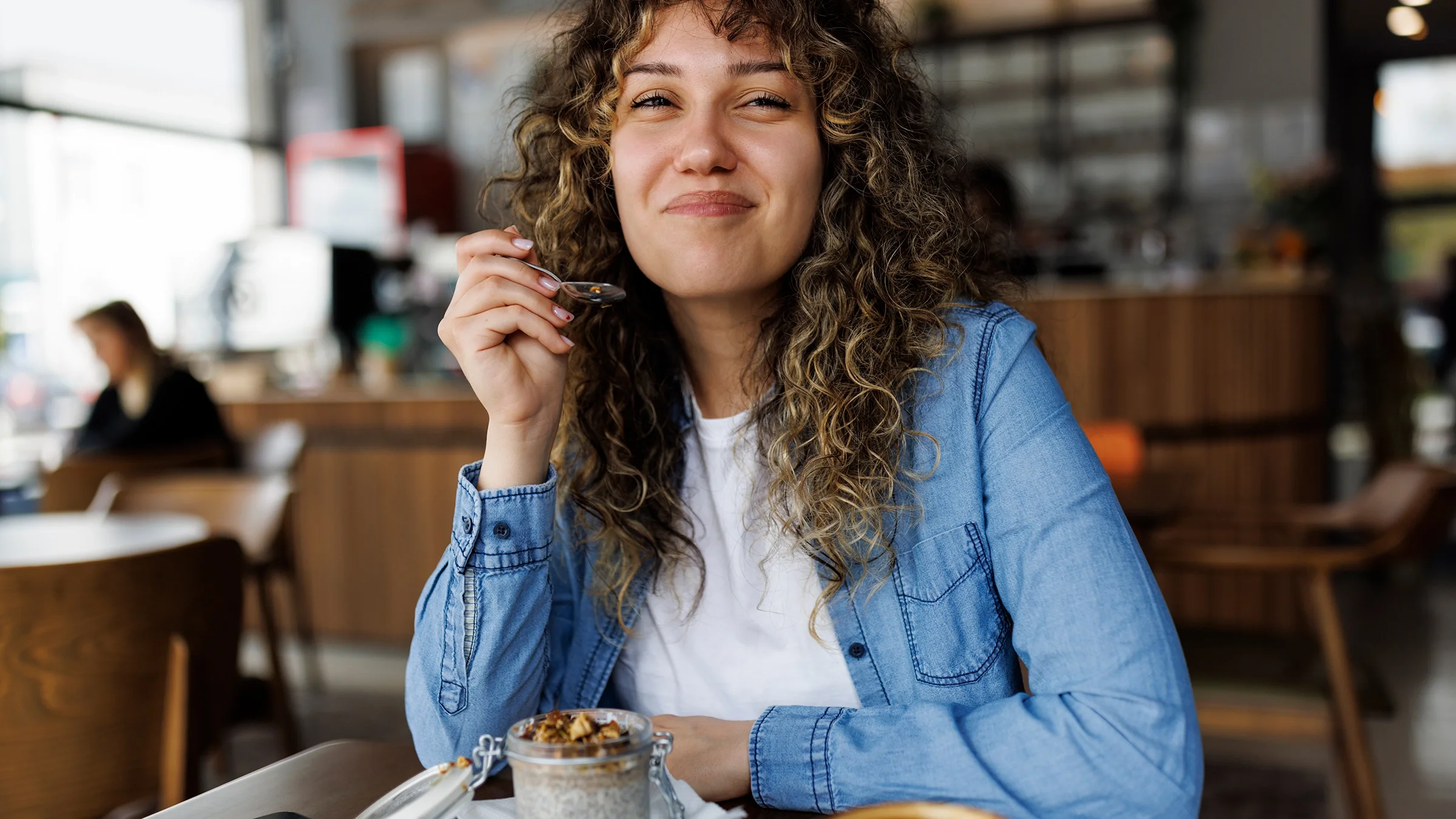 Woman eating chia pudding at a cafe.