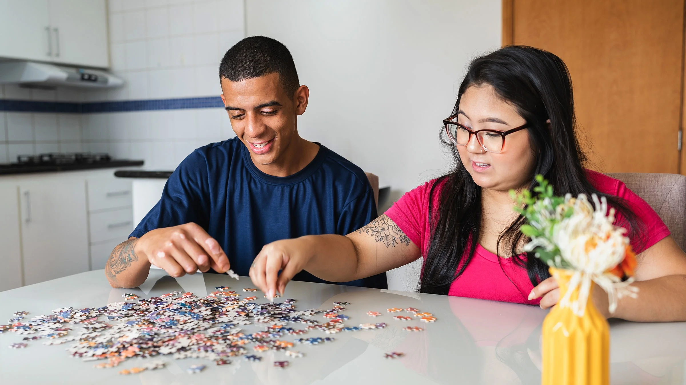 Friends assembling jigsaw puzzle at dining table