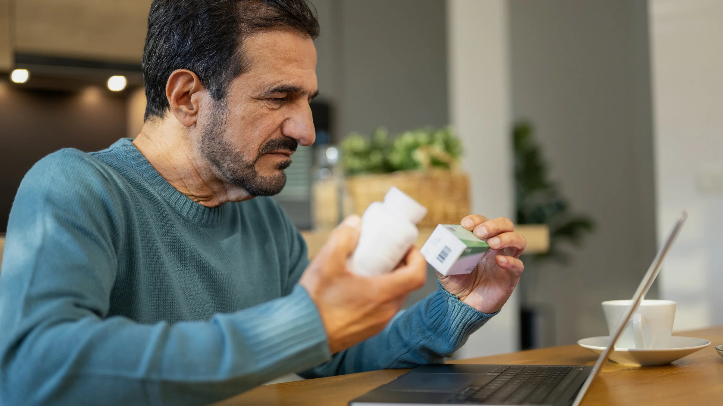 A person holding two medications and looking them up online.