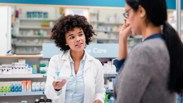 actinic-keratosis: pharmacist explaining medication 2215853180