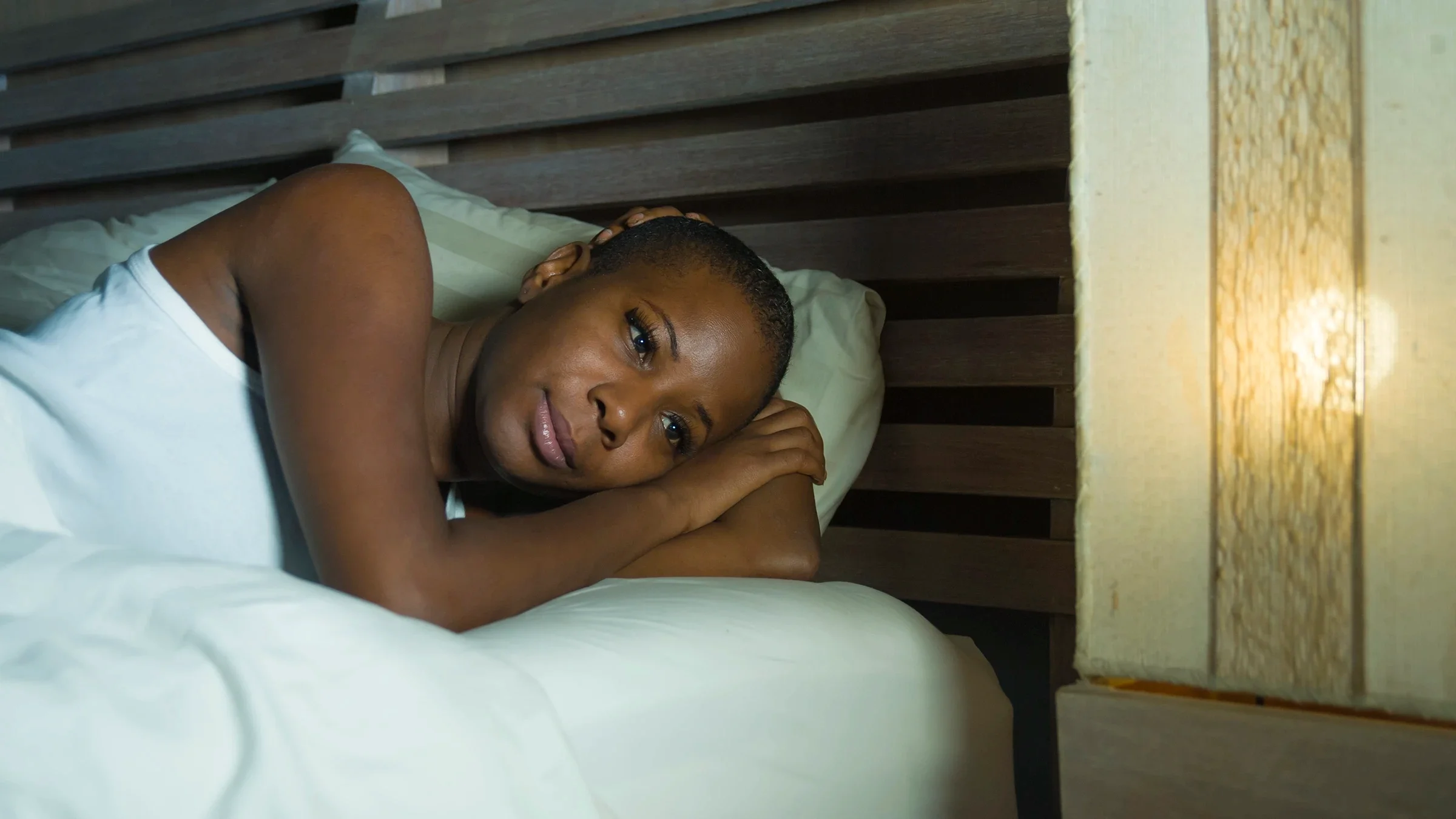Woman lying in bed with eyes open.