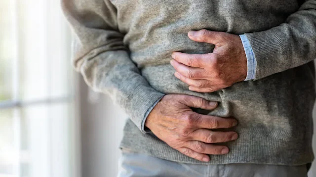 Health: Pain: man clutching stomach in pain-1253815309