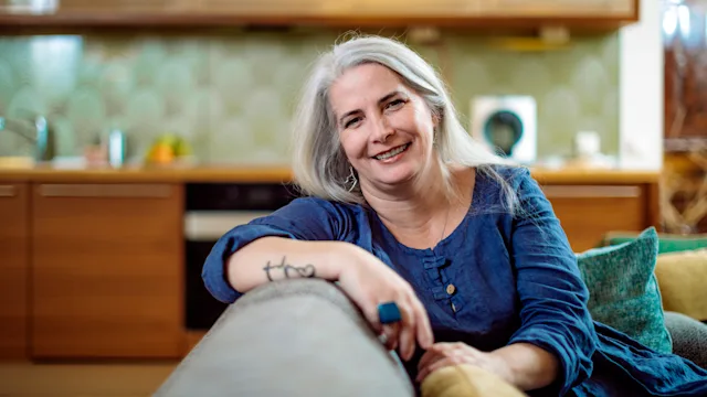 Mental-health: portrait of woman smiling at home 1077604082