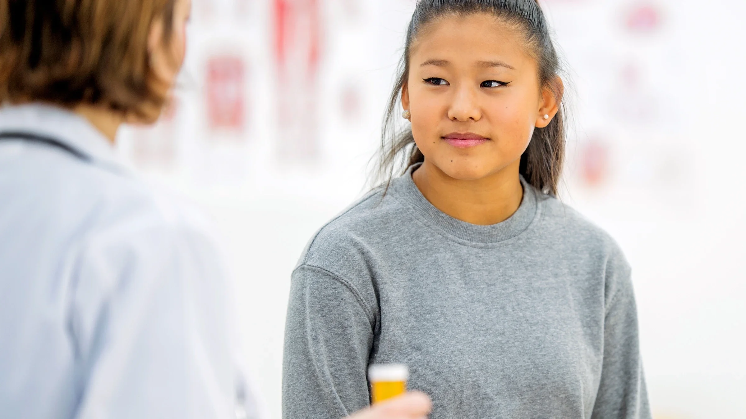 A teenage girl discusses a medication with her doctor. 