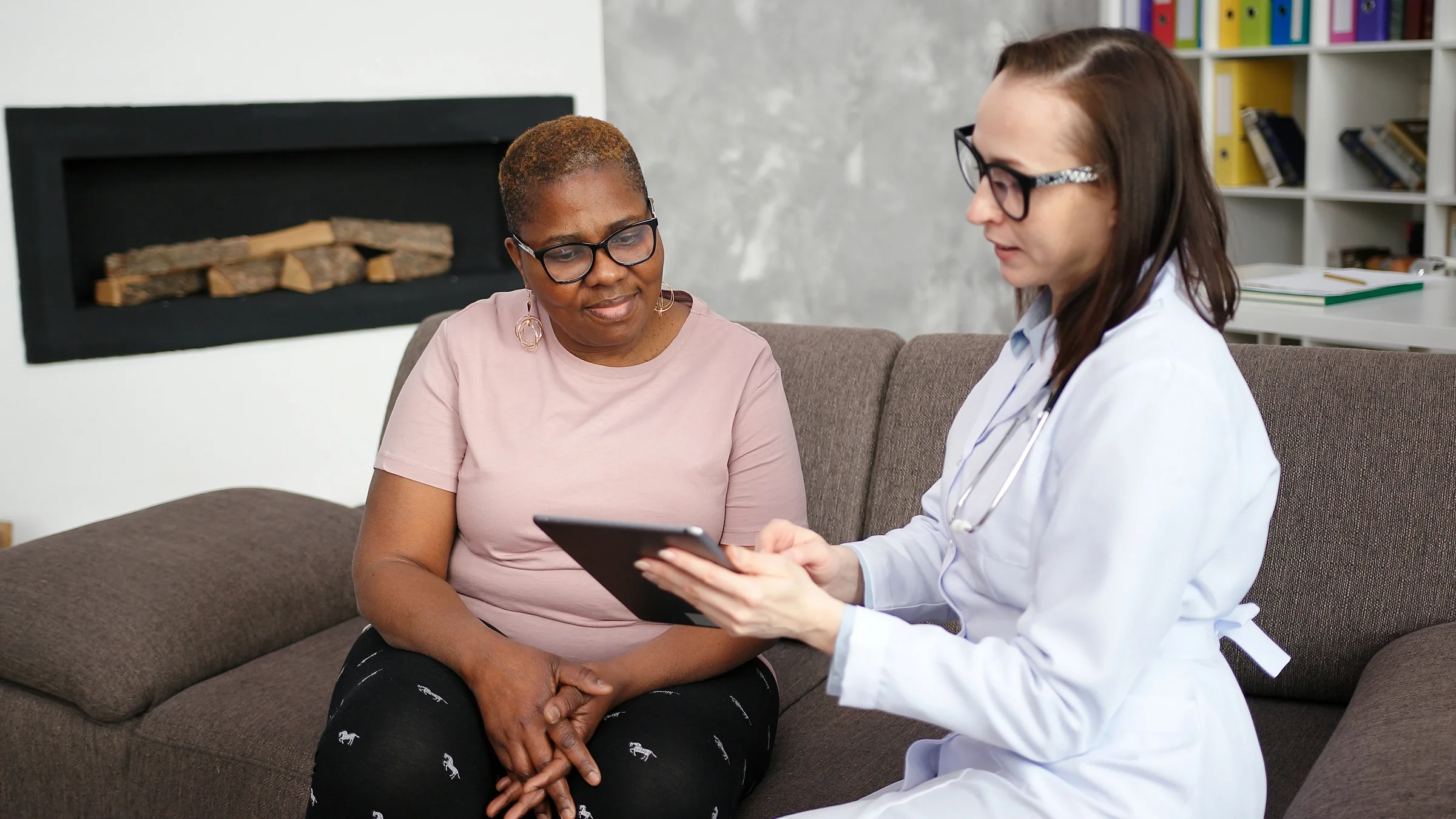 Woman with extra body fat having a consultation with a doctor. They are reviewing paperwork on a clipboard.