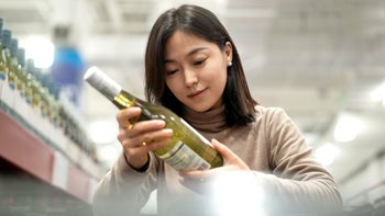 Alcohol: woman buying bottle of wine 2189307749