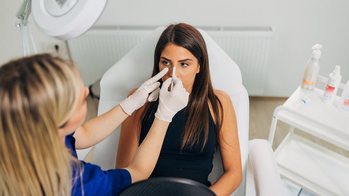 Woman having a nose job consultation with a plastic surgeon.