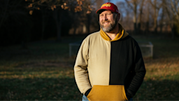 Steve Willis smiling on a crisp fall day outdoors. He is wearing a sweatshirt and a Chiefs baseball cap.
Photo by ©Taylor Glascock