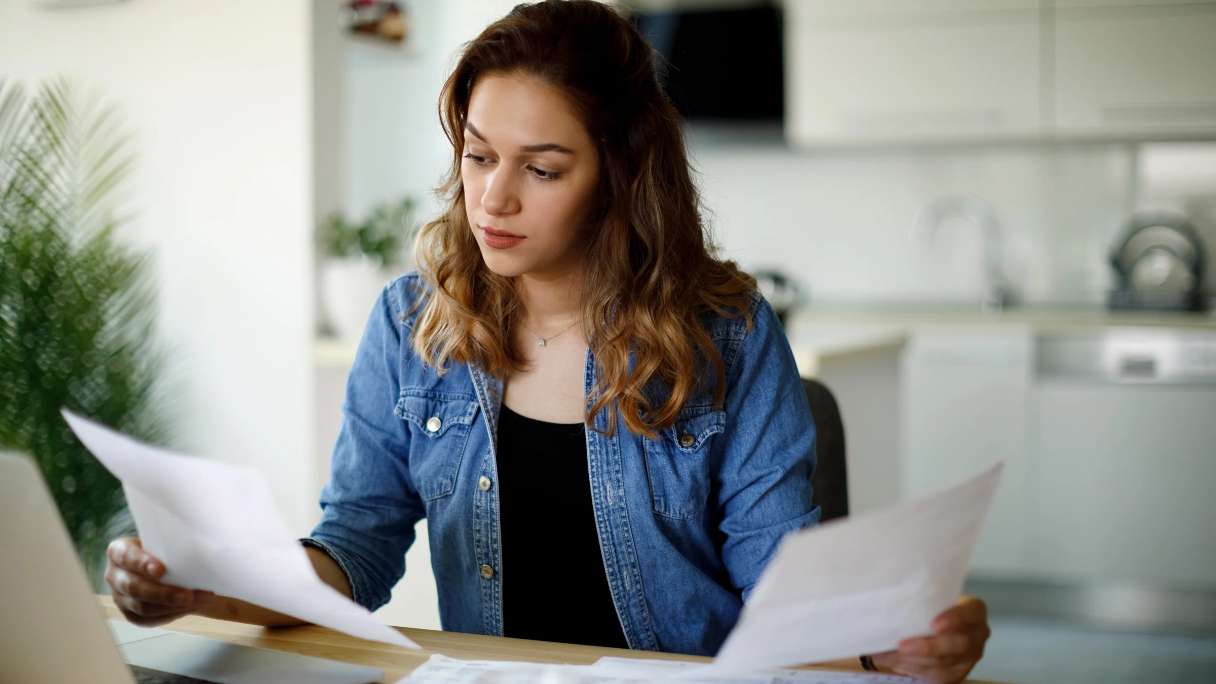 A woman reviews paperwork while preparing her taxes.