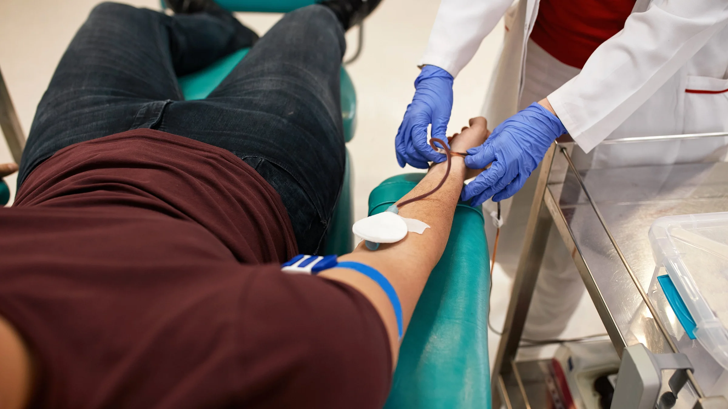 A person is donating blood. There are requirements to donate blood, including a sufficiently high level of iron.