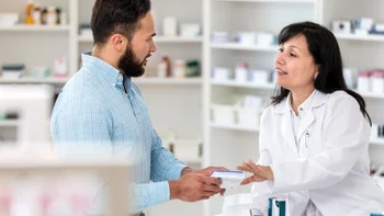 Savings: pharmacist discusses medication with customer 1165345393