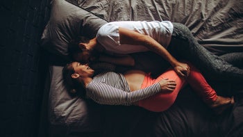 Pregnancy: pregnant woman and man lying in bed 870773732
