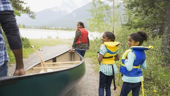 Environmental: family carrying a canoe to the lake 1432535878