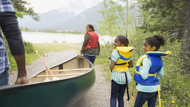 Environmental: family carrying a canoe to the lake 1432535878
