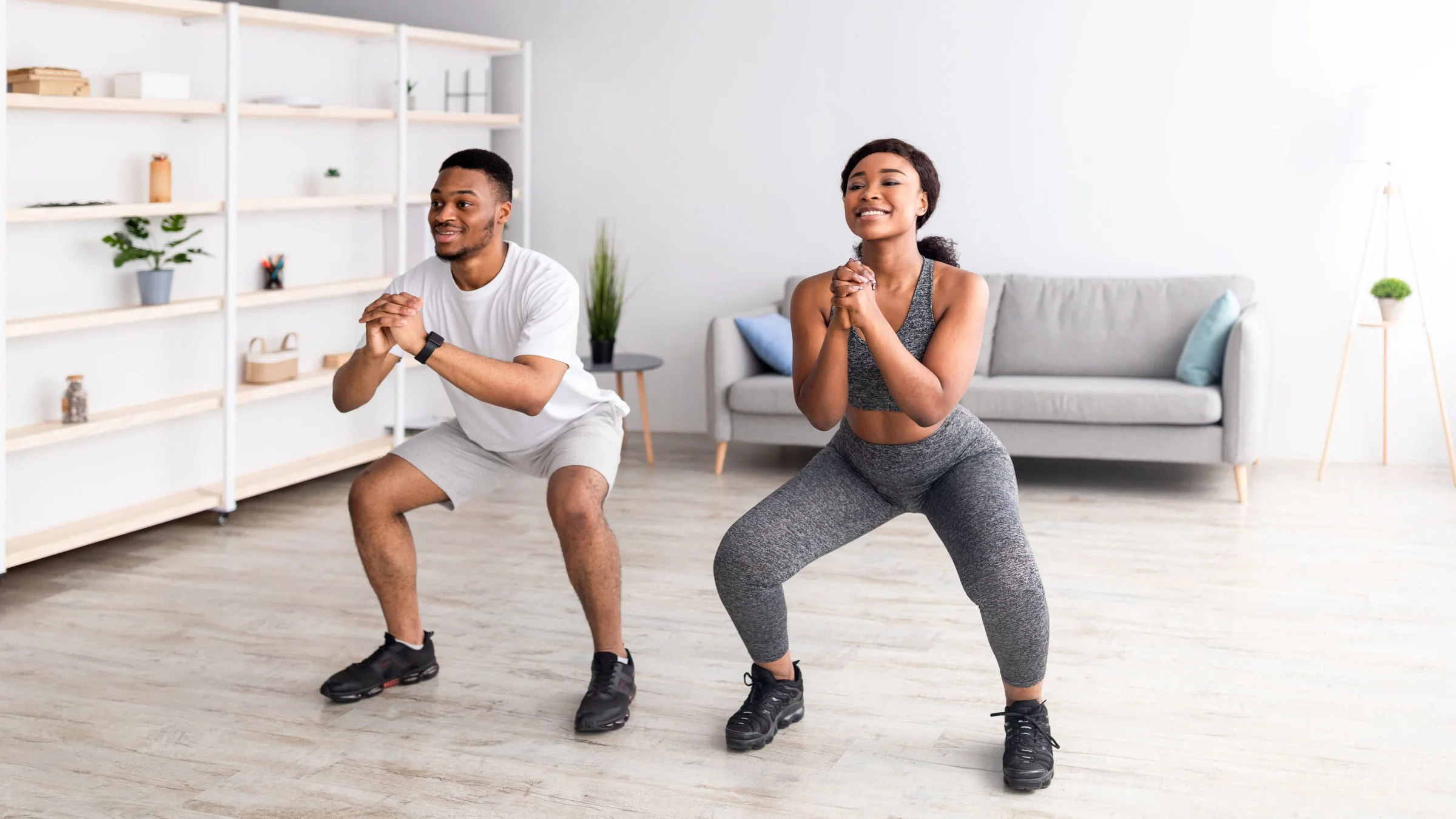Couple doing squat exercise at home