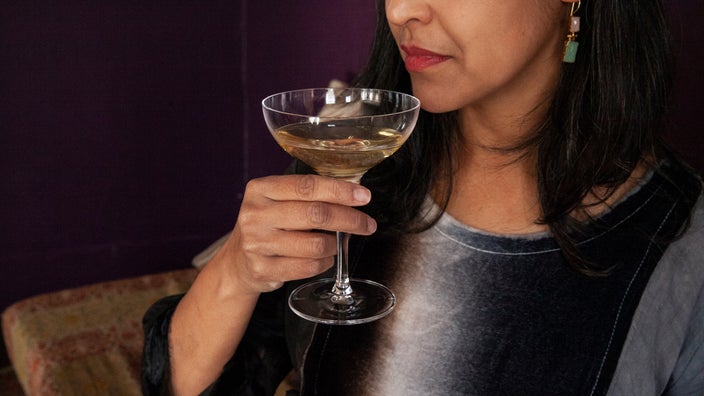 A woman is holding a champagne glass in a close-up.