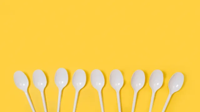 Mental health: Spoon theory: white plastic spoons on yellow background-1225517308