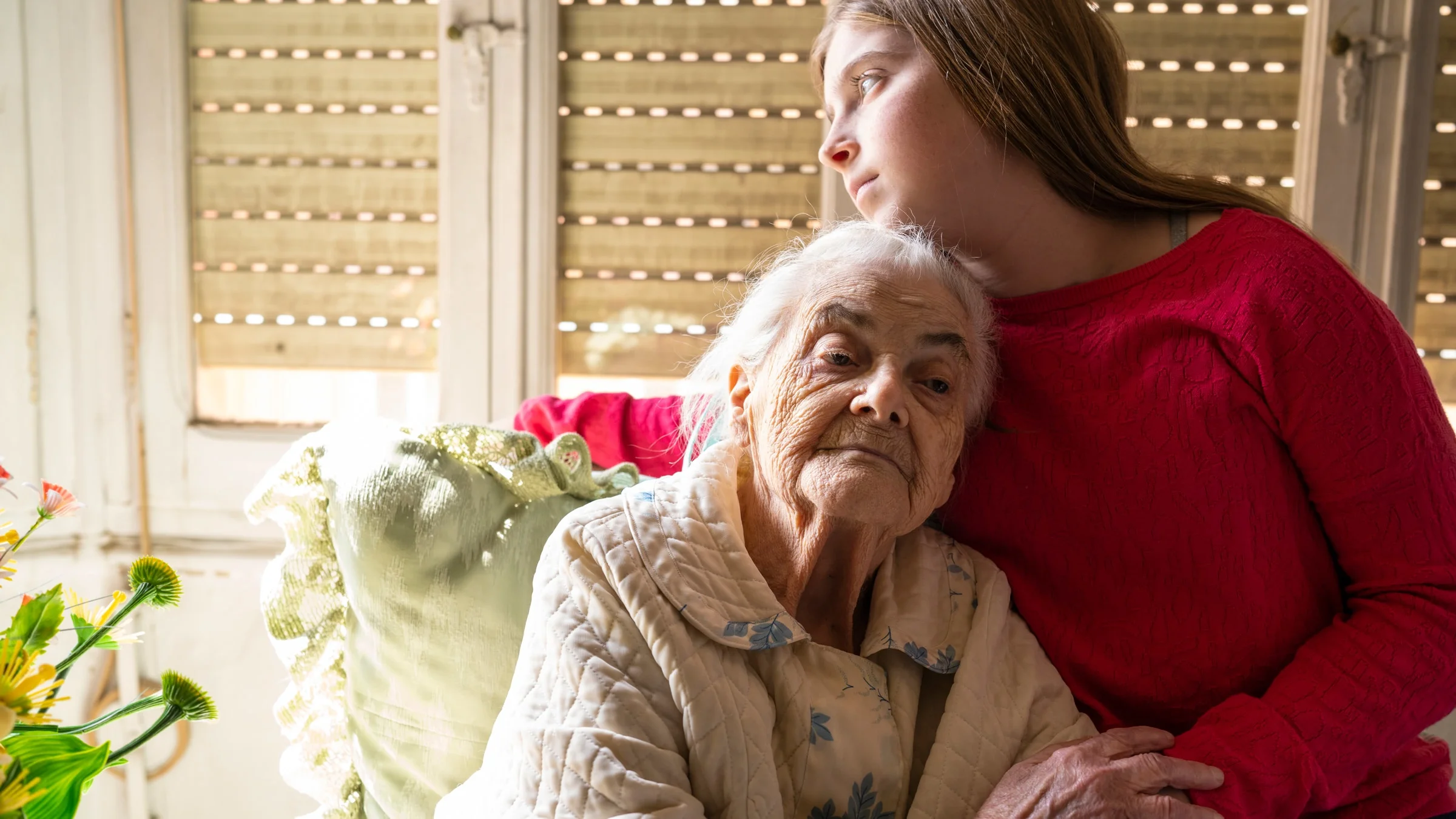 A grandparent and grandchild comforting each other. 