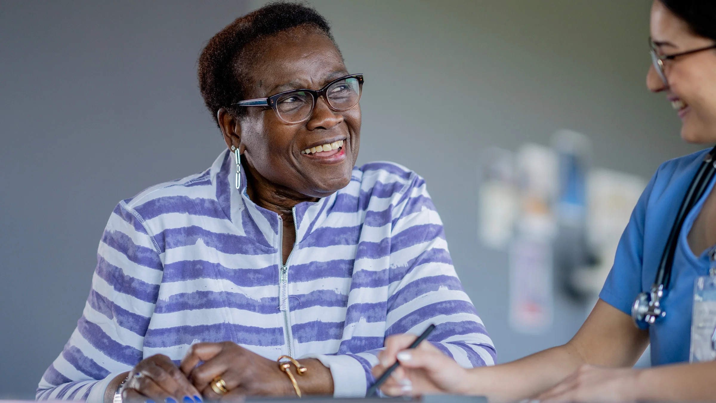 An older adult speaks with a healthcare professional during a medical appointment.