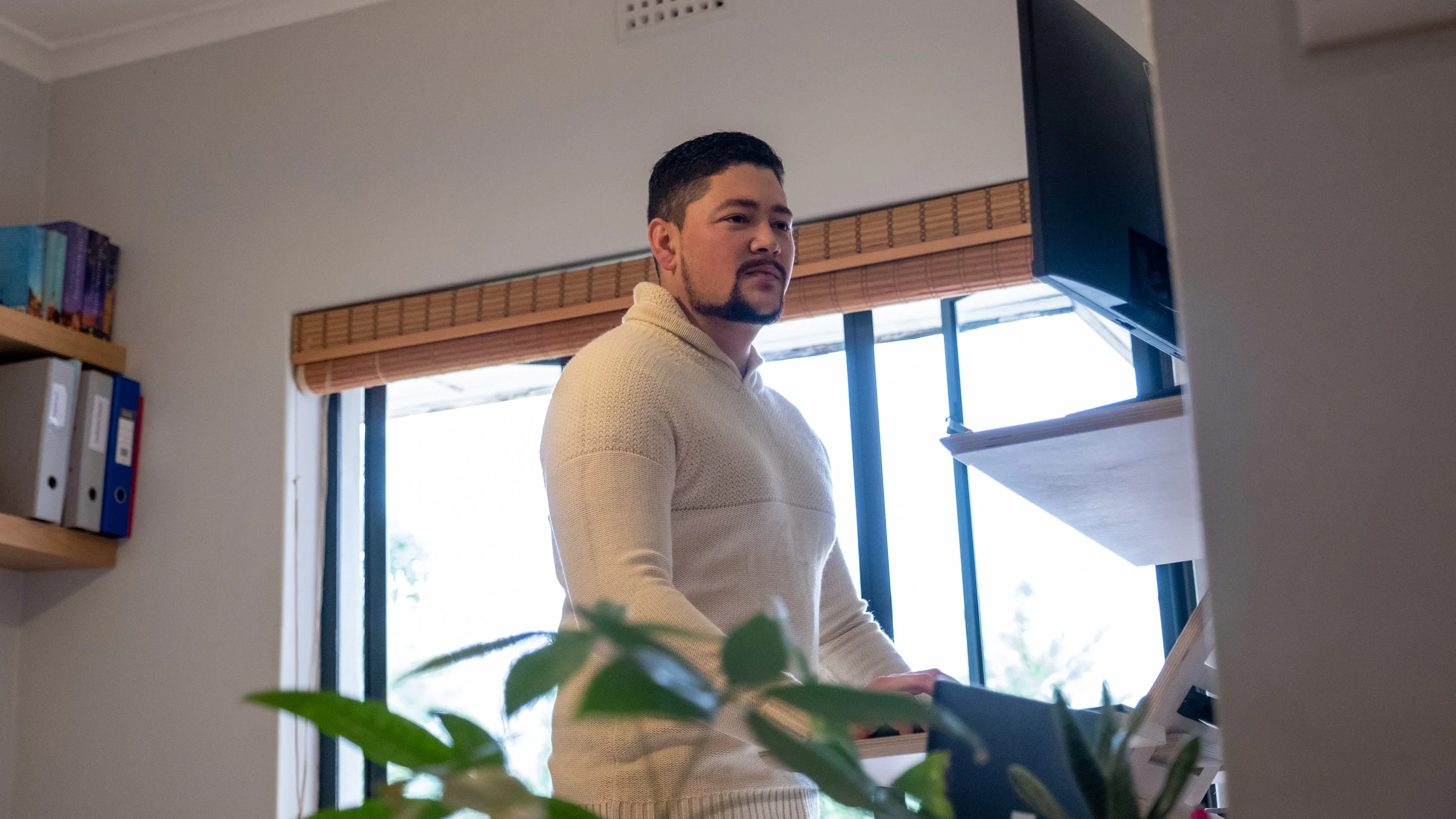 A man works from home at a standing desk.