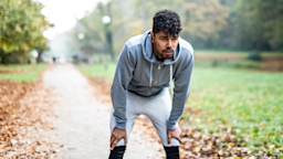 Man exhausted mid run through the park. He is bent over with his hands resting on his knees.
DjelicS/E+ via Getty Images