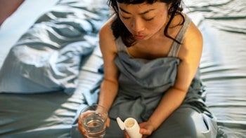 Health: Melatonin: woman taking medicine in the bedroom 1482426540