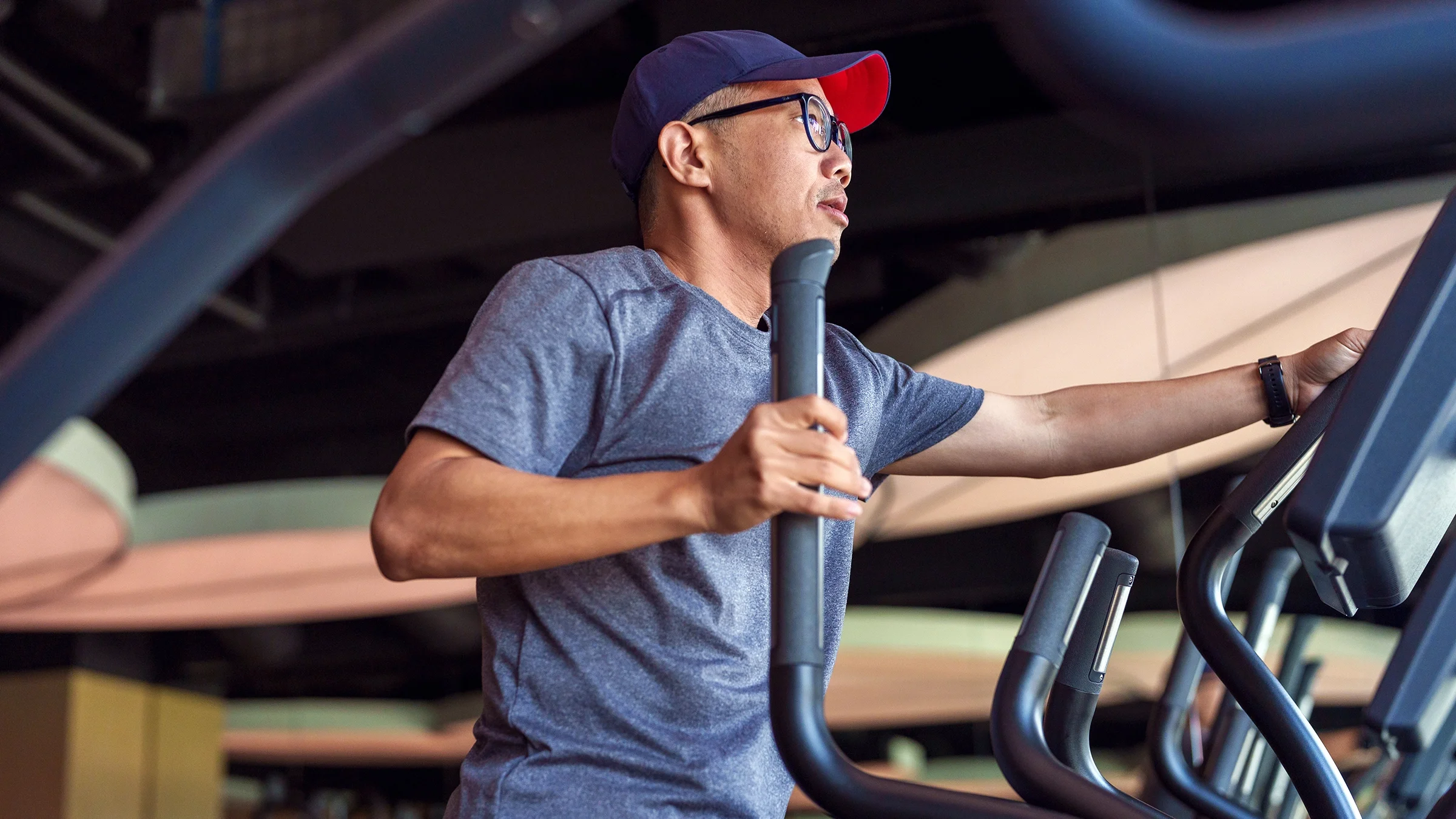 A man is exercising on an elliptical machine.