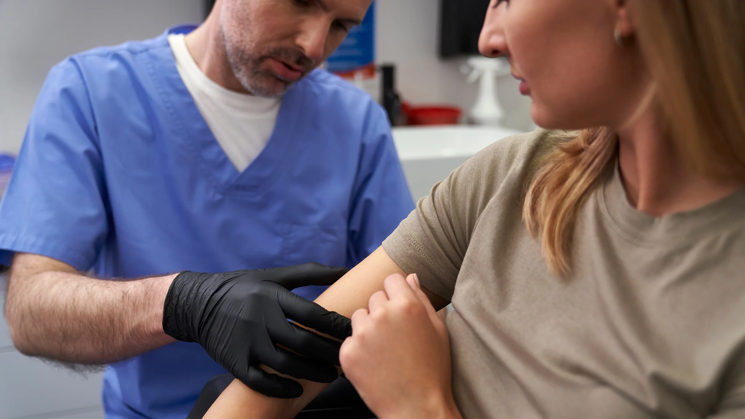 Healthcare professional checking woman's arm.
