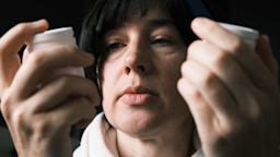 A close-up of someone examining and comparing two pill bottles.
invizbk/E+ via Getty Images 