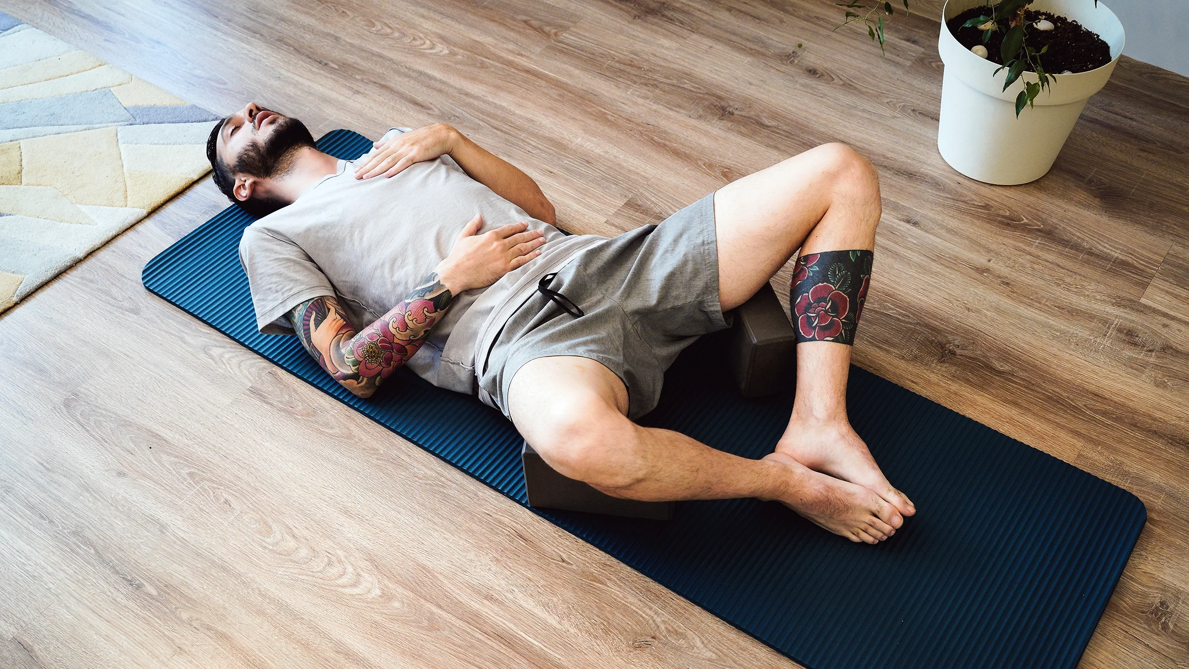 An adult is doing diaphragmatic breathing exercises on a yoga mat.