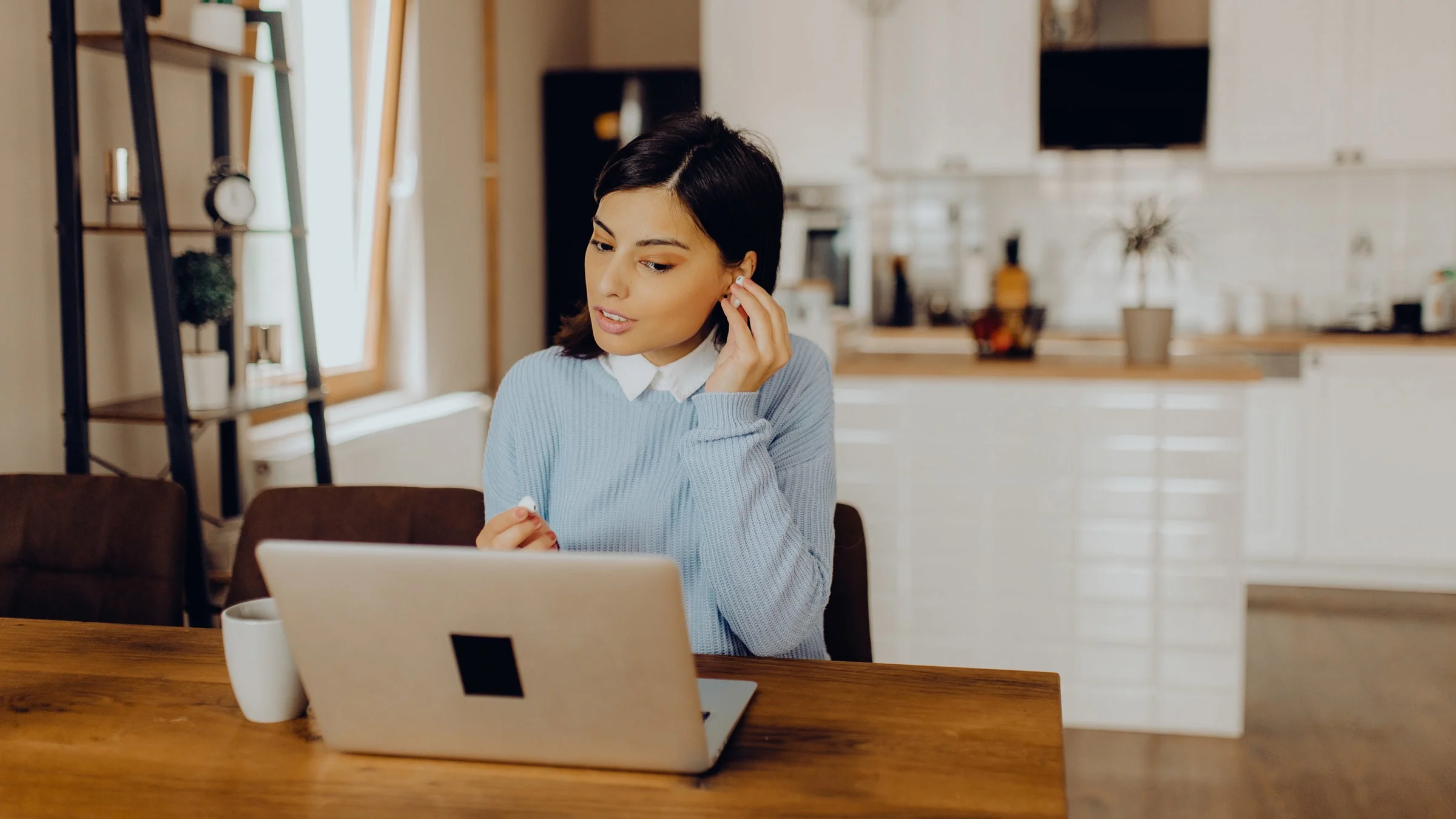 A person adjusting their wireless earphones in a video call.
