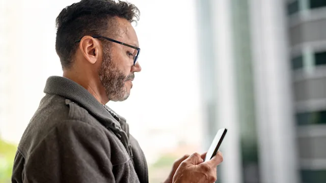 Mental-health: man texting on mobile phone 1060895682