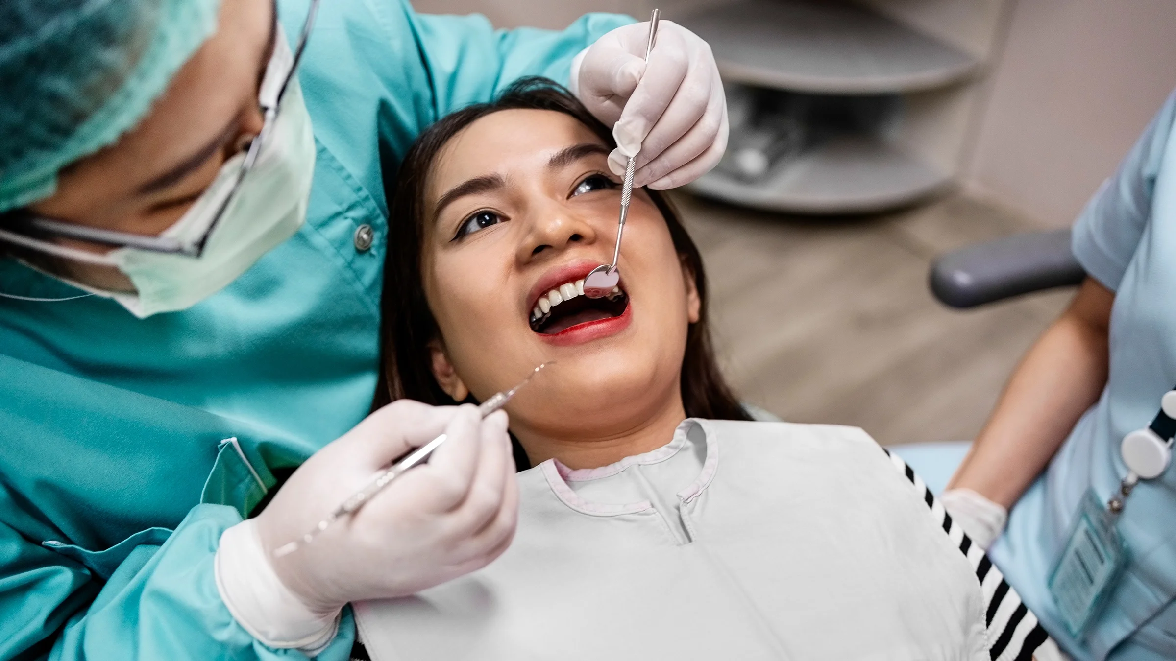 A woman gets her teeth checked at the dentist.