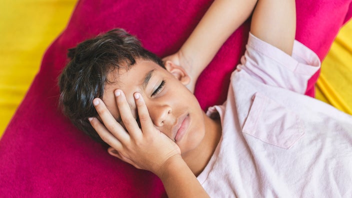 An overhead view shows a child with a headache.
