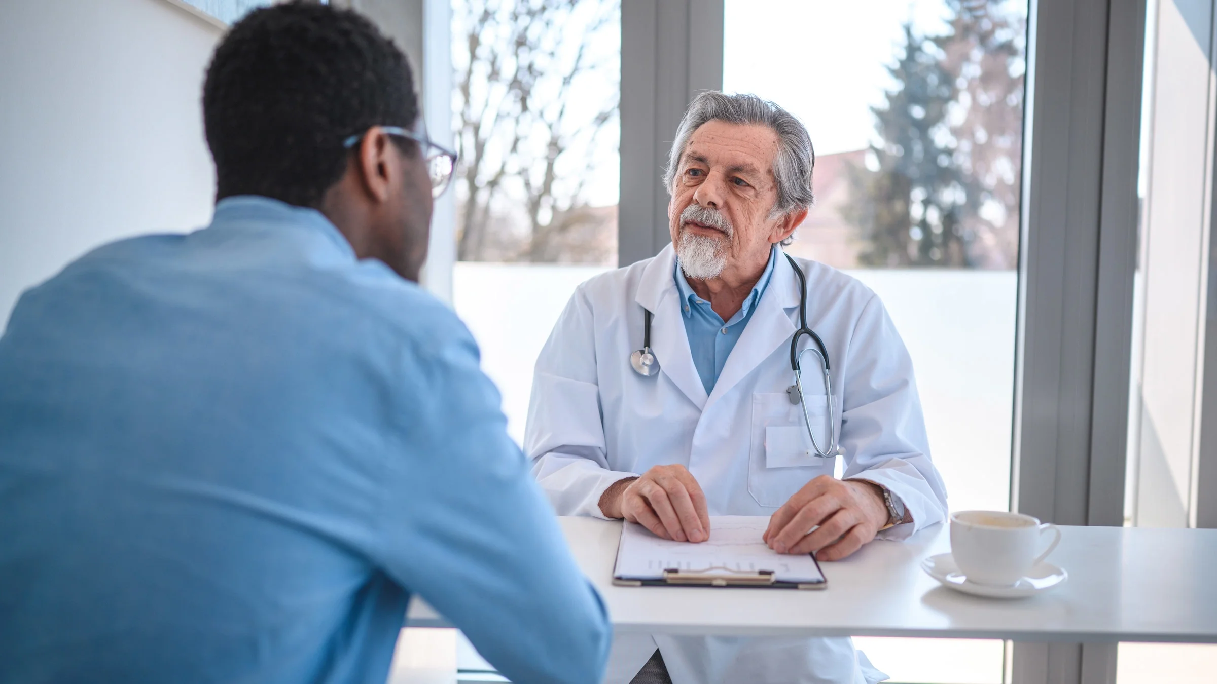 A healthcare provider talks with a man during a consultation. Lumps and bumps in the testicles can be caused by injury, infection, or cancer.