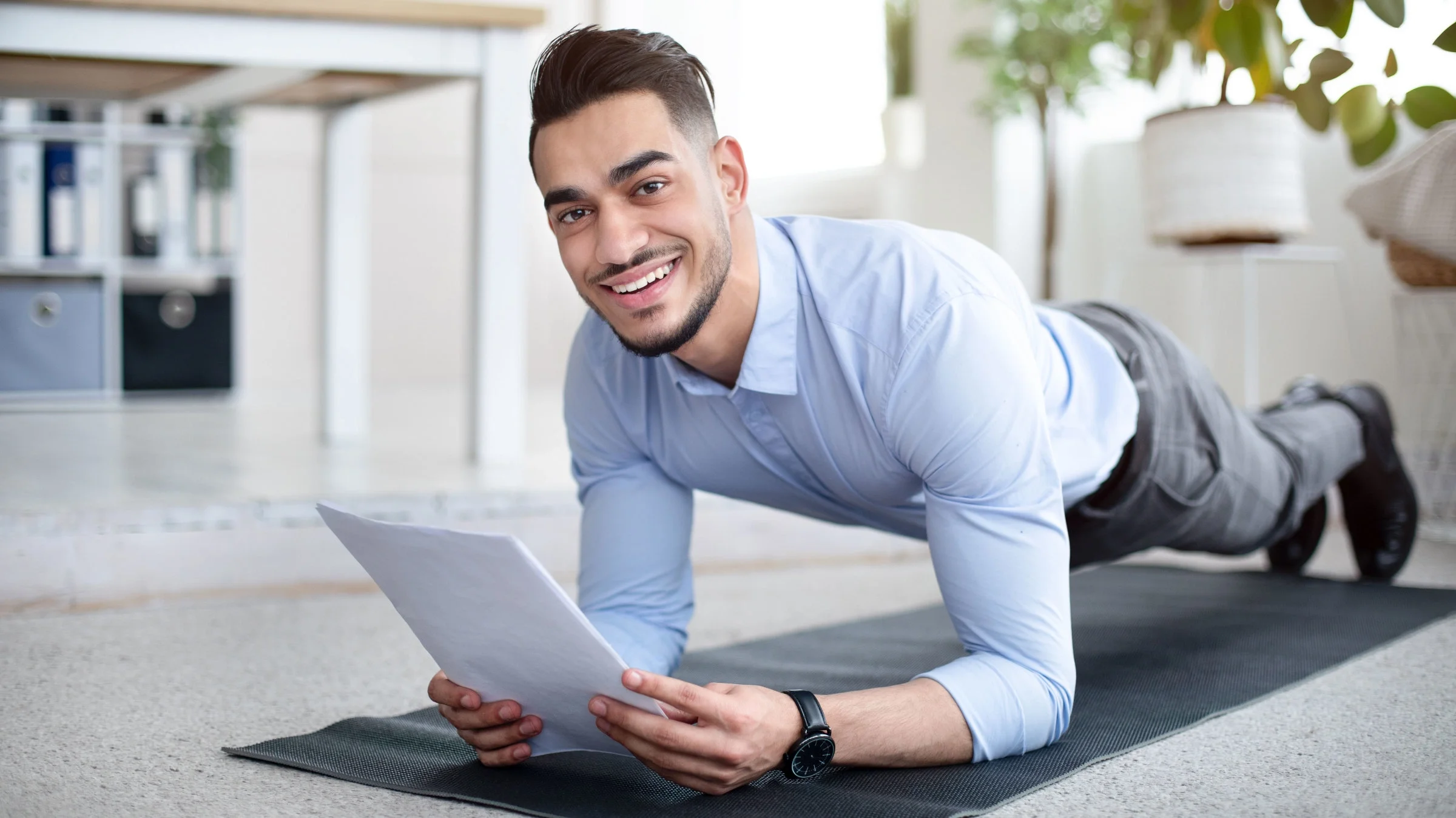 A man is doing a plank exercise while at work.