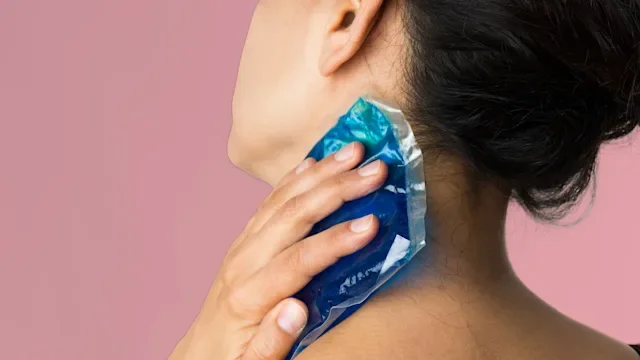 Health: Dermatology: closeup woman placing ice pack on neck 1051431514