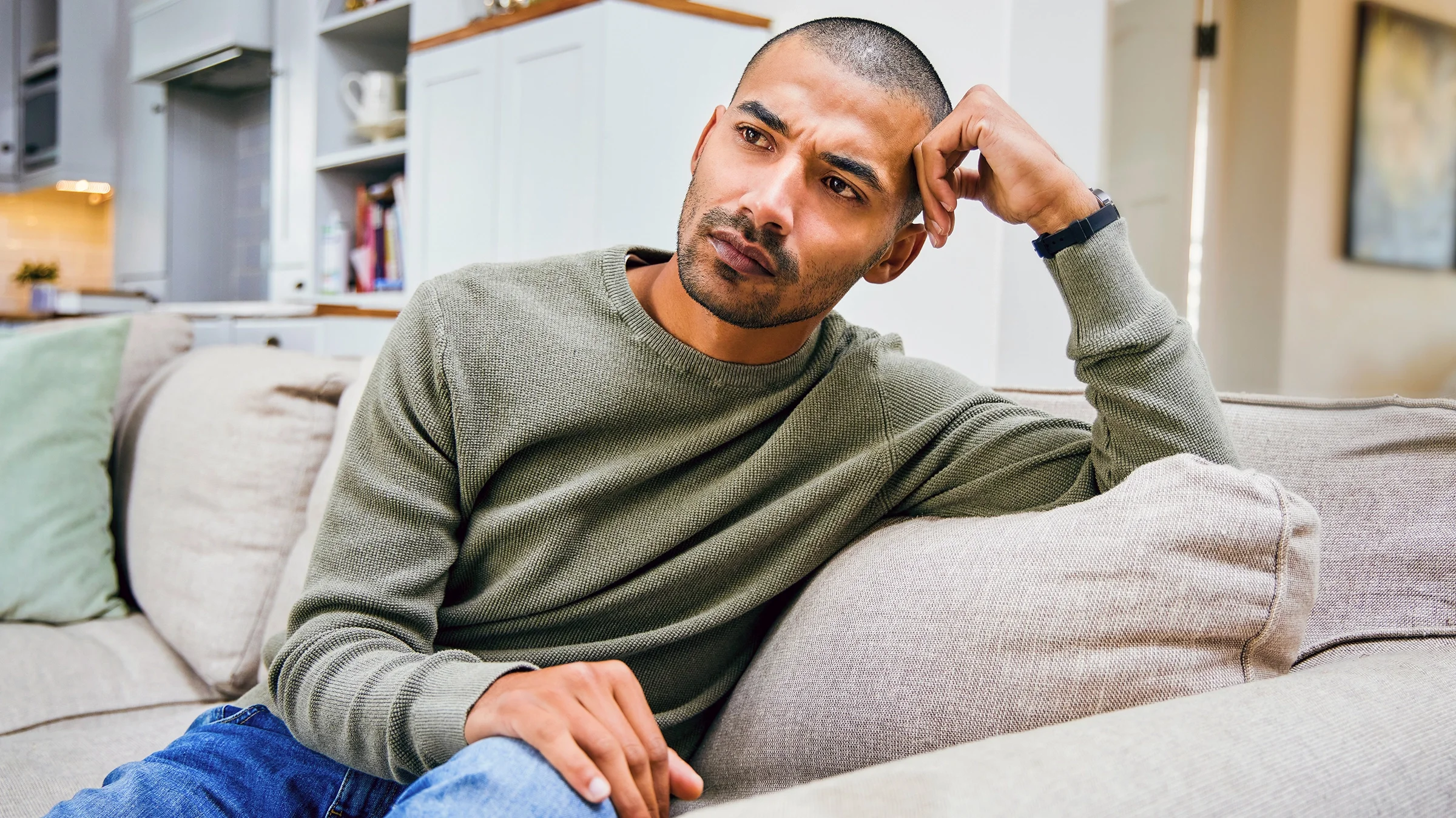 Man in deep thought while sitting on the sofa