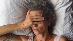 Someone suffering from headache in bed.
natalie_board/iStock via Getty Images Plus 