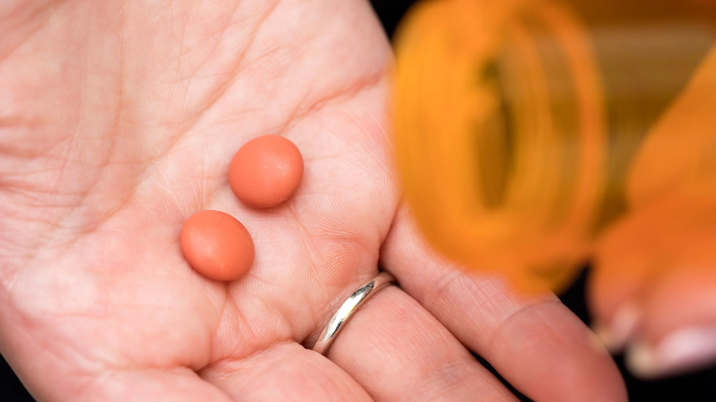A close-up of ibuprofen pills in the palm of a hand.