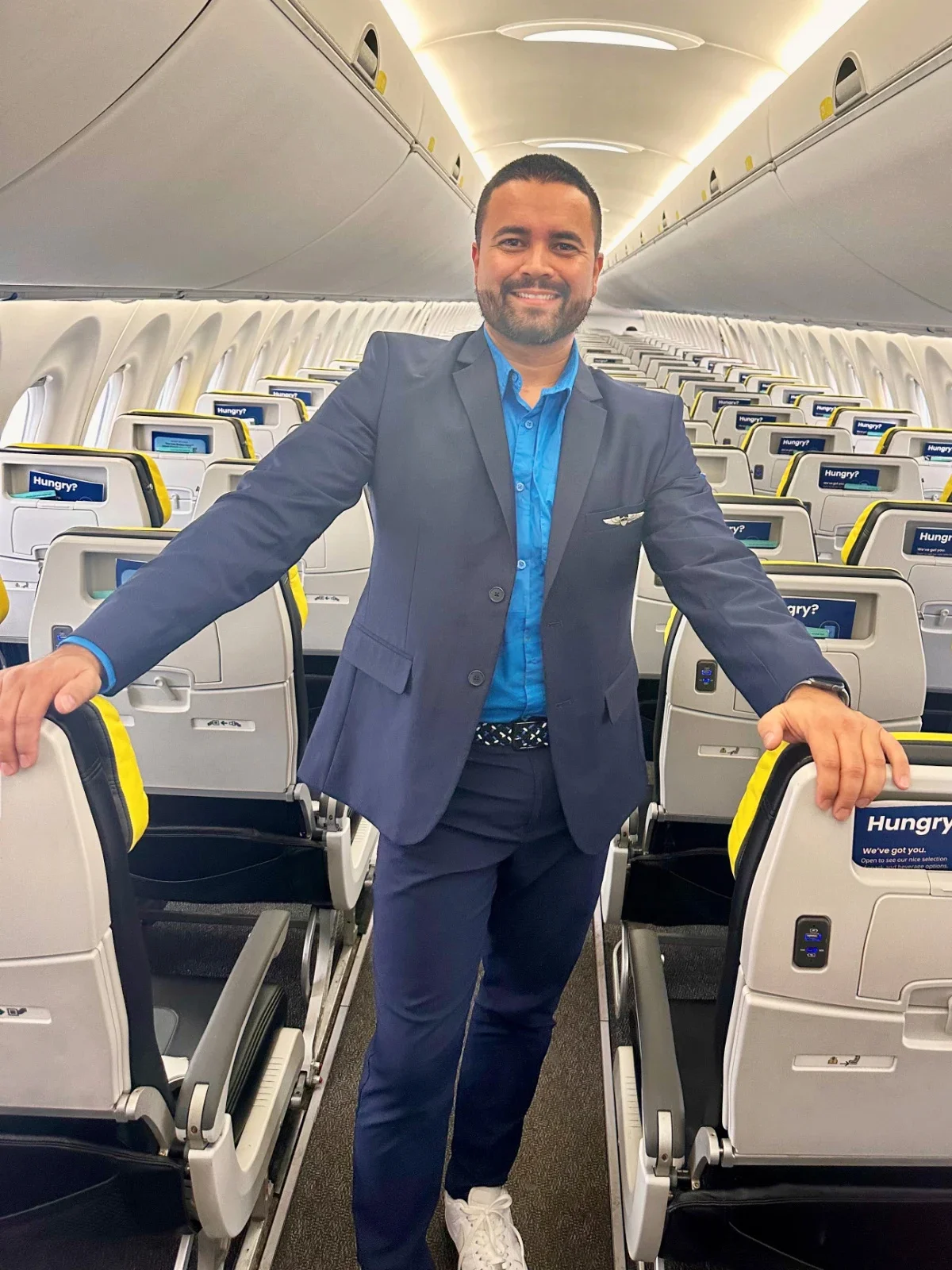 Ricardo Louzada is pictured standing in the aisle of an empty plane.