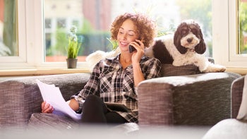 Pet health: phone call on couch with dog holding bill 540591506