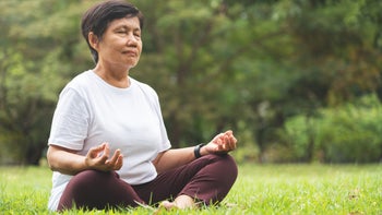 Health: Mental health: meditating in park-1200861884